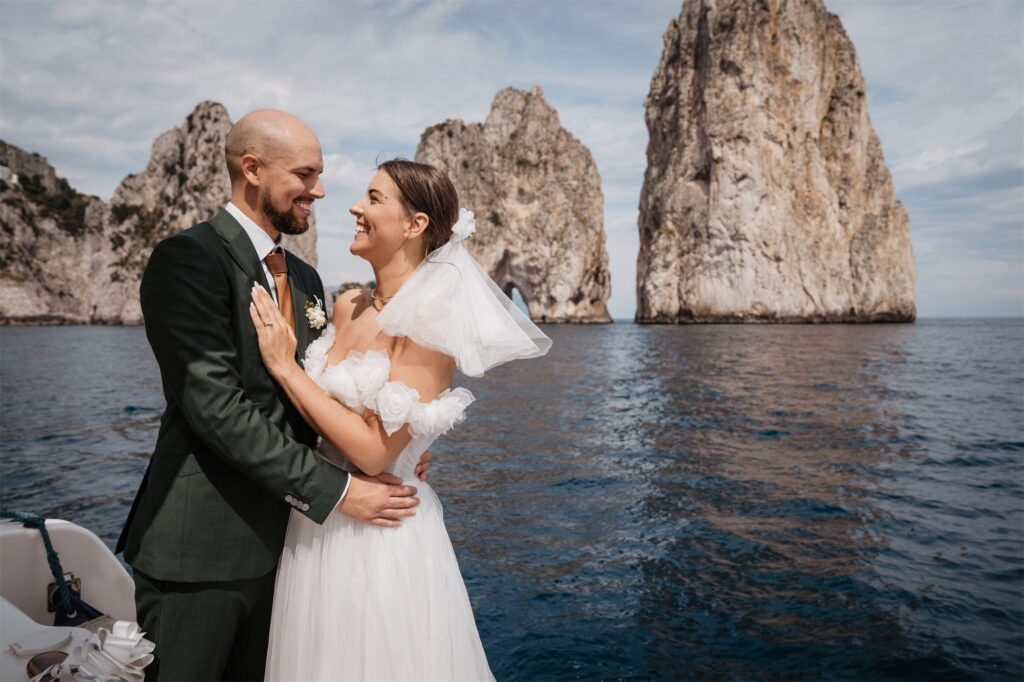 Thomas e Solenne abbracciati in barca davanti ai Faraglioni di Capri
